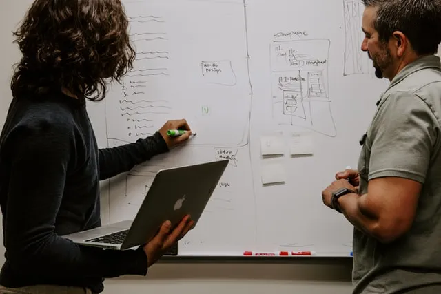 Two people brainstorming on table